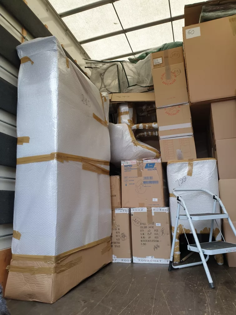 Un camion de déménagement rempli de boîtes et de meubles entassés.