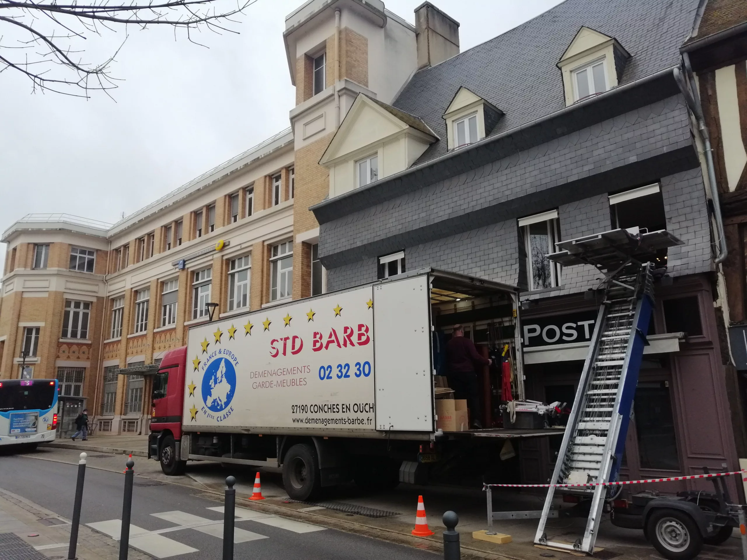 Un camion de déménagement stationné devant un immeuble, indiquant un déménagement en cours ou imminent.